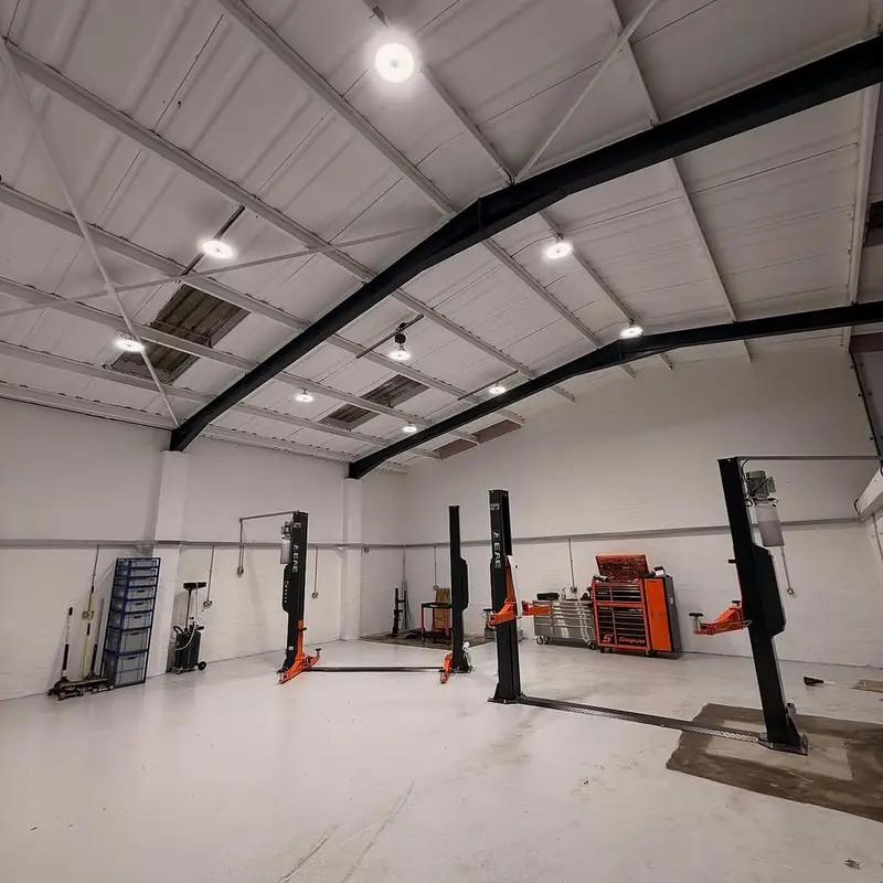 Low-bay LED lights fitted by Renovolt over the vehicle bays in a Bridgend car garage workshop