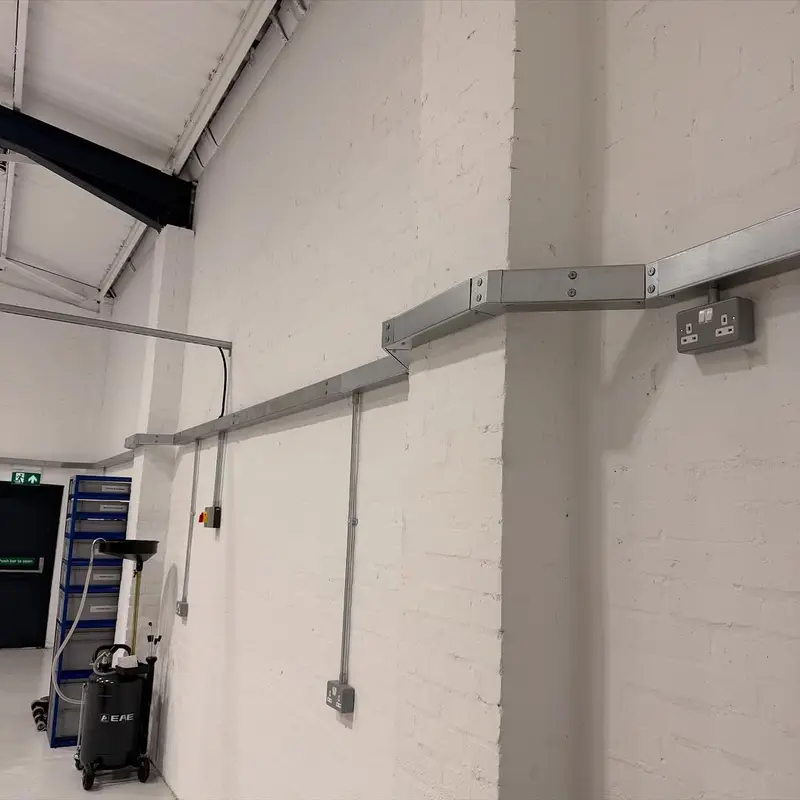 Wall sockets run in surface steel conduit in a Bridgend garage workshop, installed by Renovolt